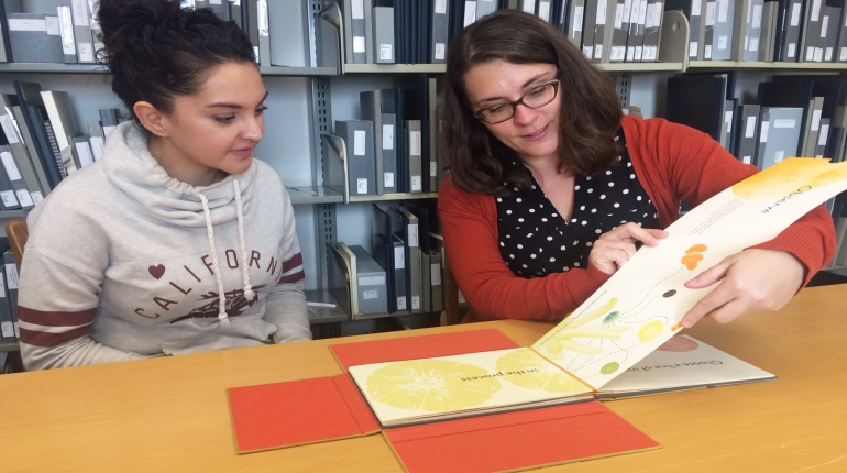 Student consults with librarian about artists' book research.