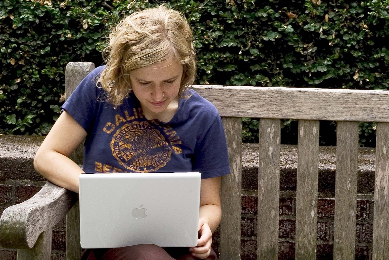 Person sitting on a bench using a labtop computer