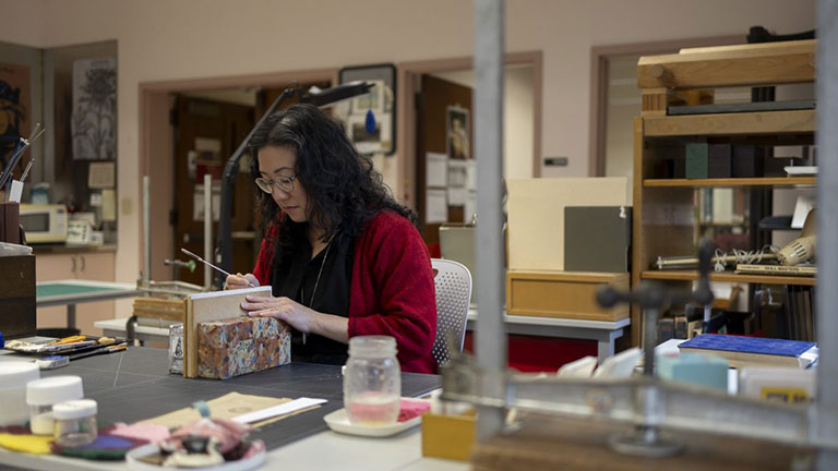 Lead Conservator Victoria Wong works to restore the binding of a book in the UO Libraries' collection. 