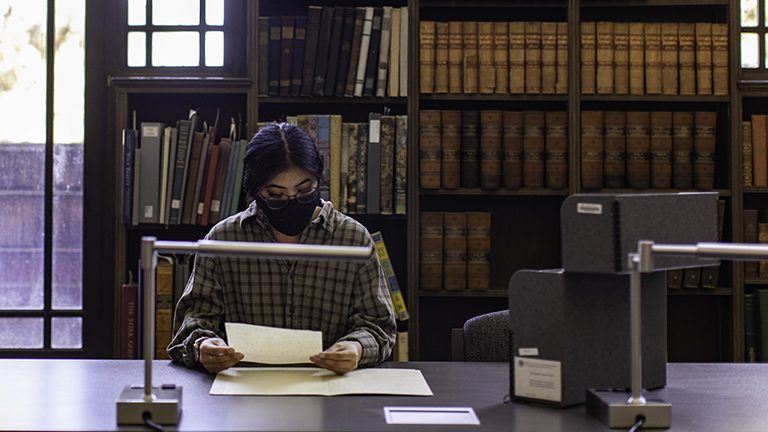 Reasearcher looking at materials in the special collections reading room