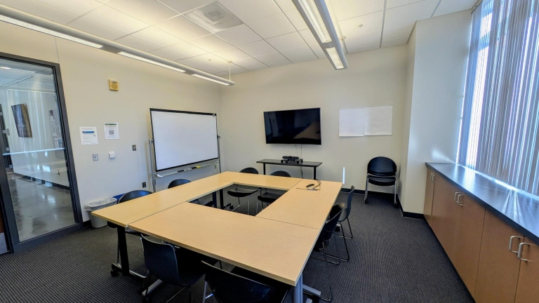 Conference room hollow square table wtih whiteboard and screen on wall