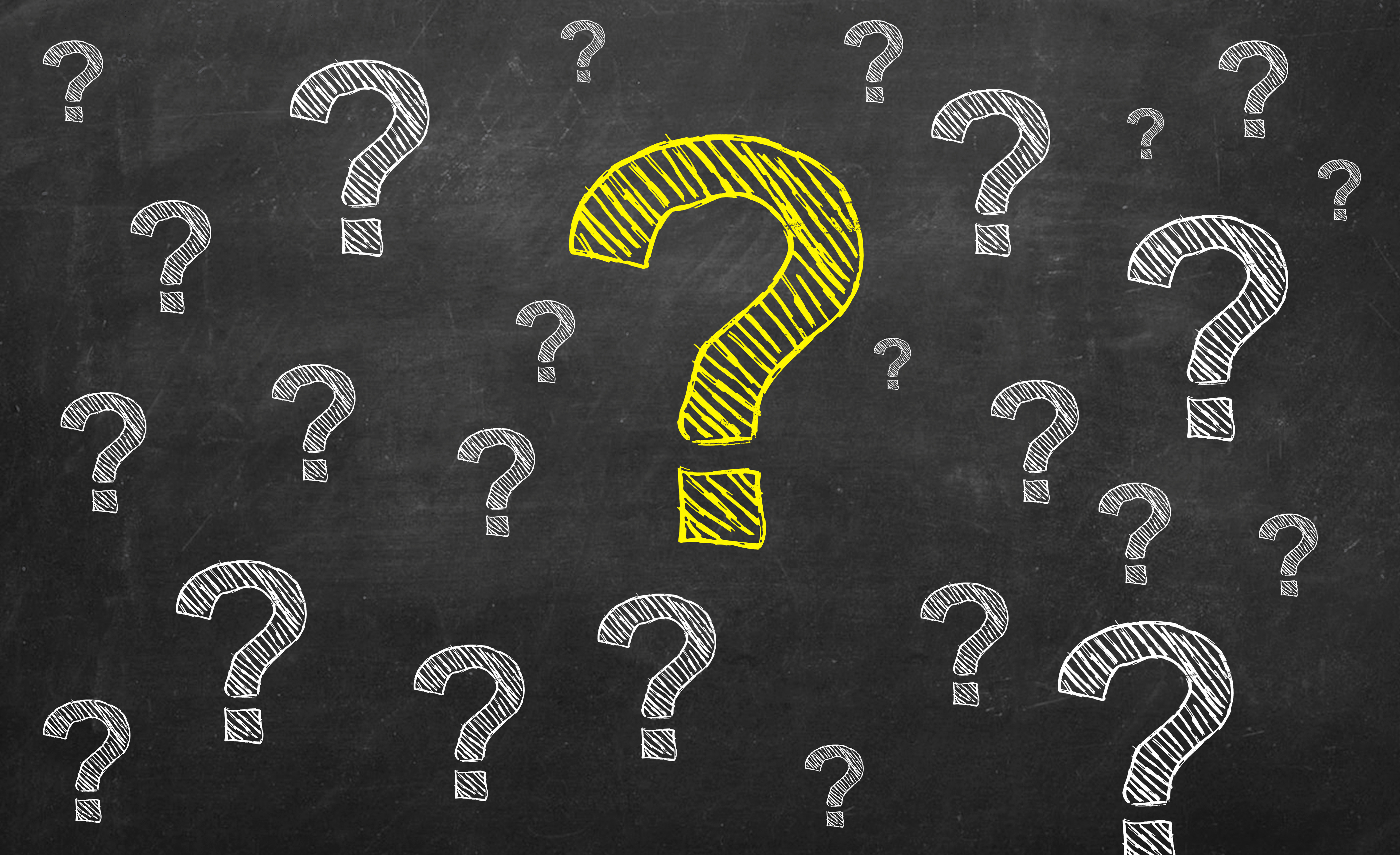 Question marks in chalk on a chalk board.