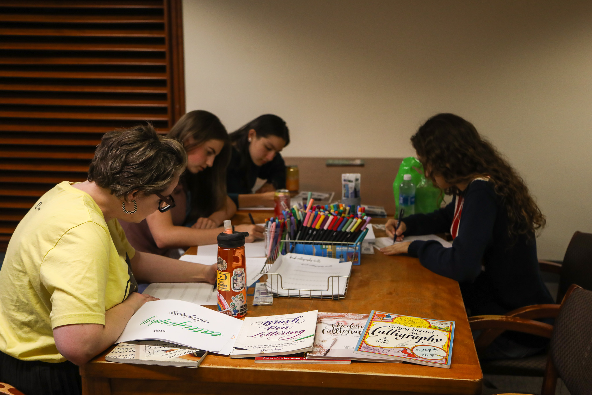 Students and librarian writing calligraphy.