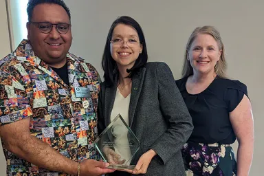 Gerard Sandoval (left), Alicia Salaz (center), and Evey Lennon (right) celebrate Salaz&#039;s recognition