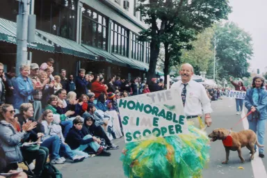 Peter DeFazio pushing a wheelbarrow filled with "slime" in the Eugene Celebration Parade, circa 1980s.