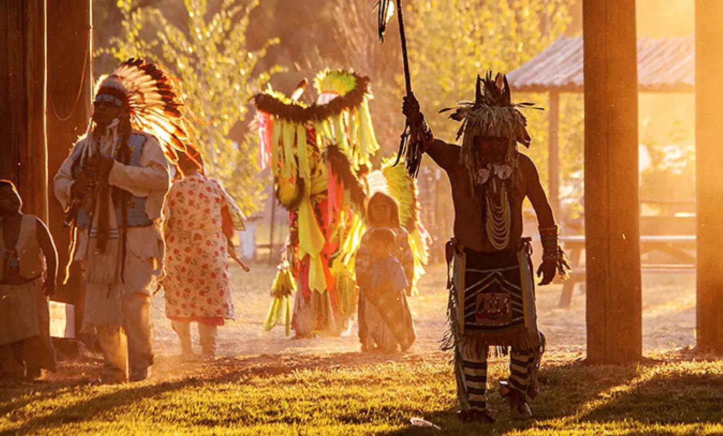 Photo, courtesy of Joe Whittle from his Landback project, depicts Indigenous dancers and children watching them.