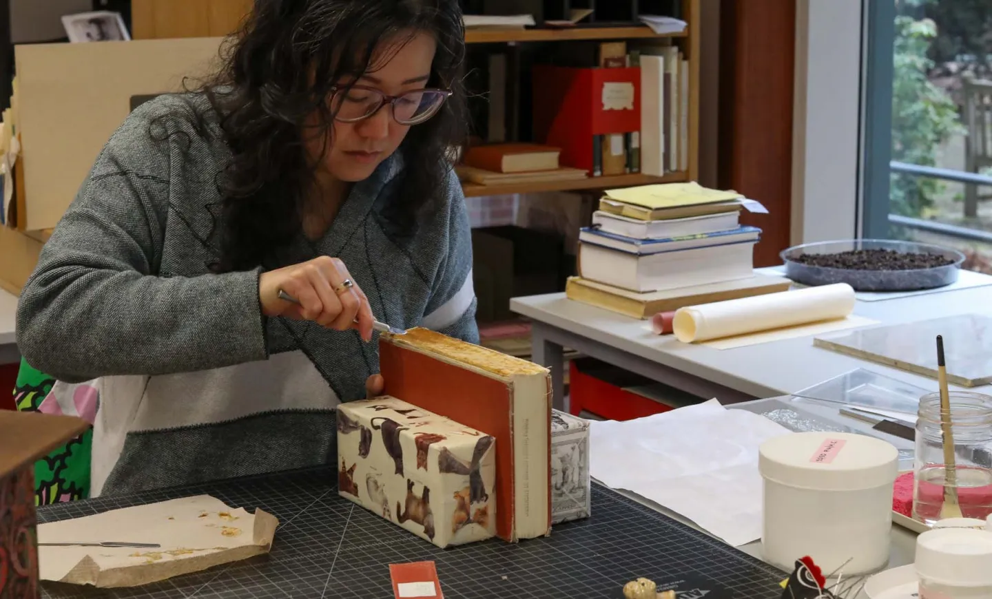 Victoria Wong repairing the spine of an old book in the UO Libraries' Beach Conservation Lab