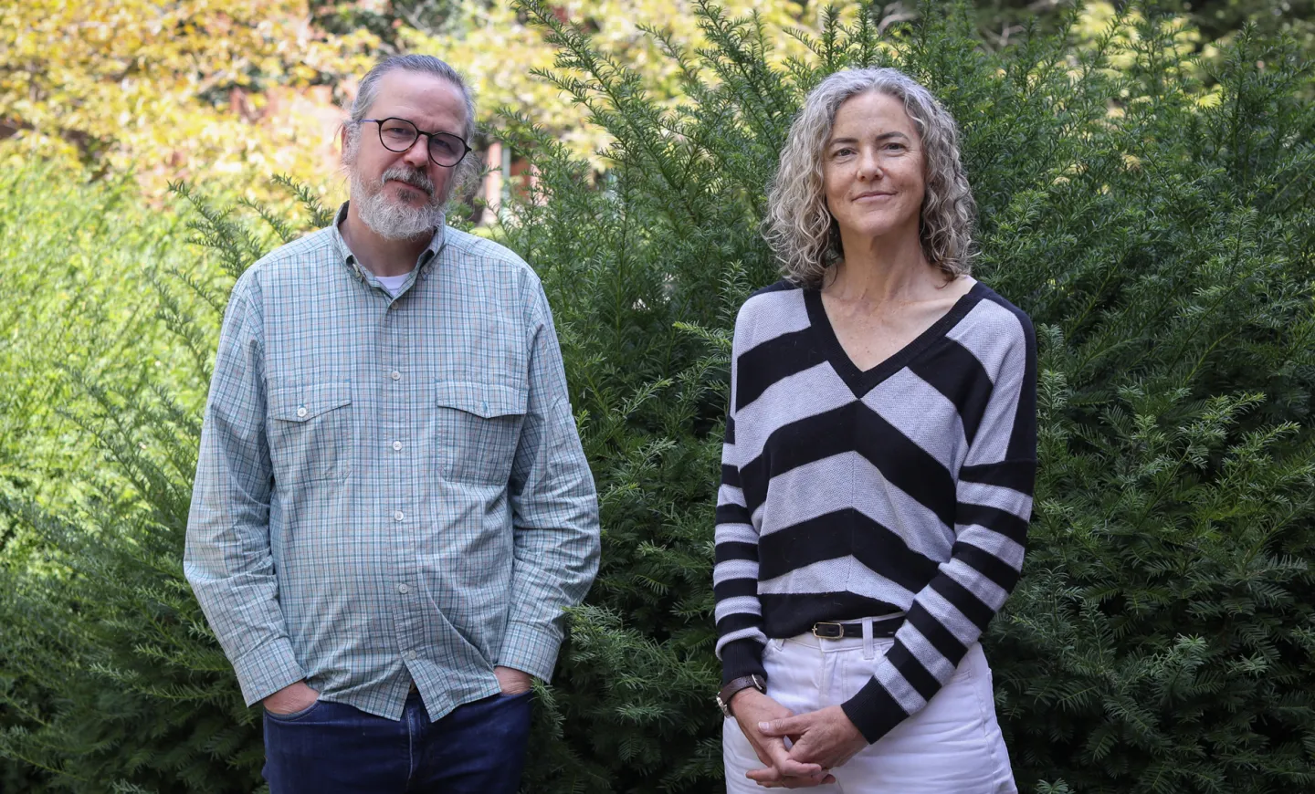 Justin Spence and Elizabeth Peterson standing against a backdrop of campus greenery.