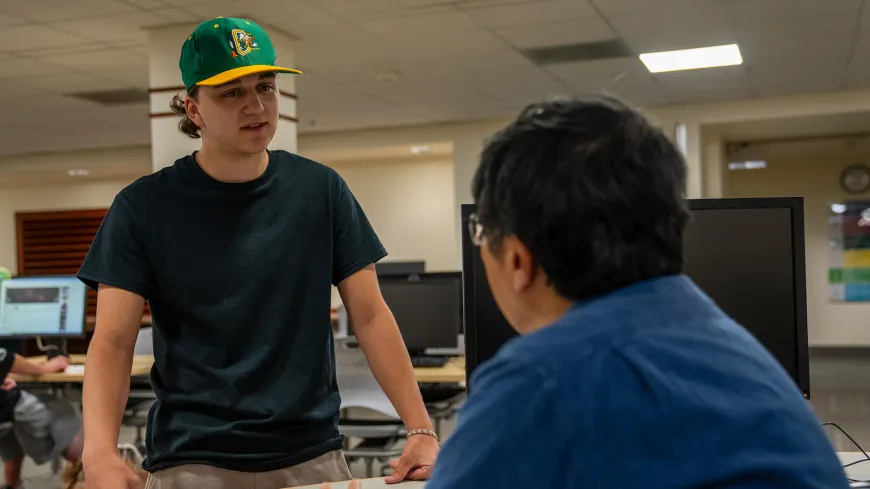 Two people talking in the library