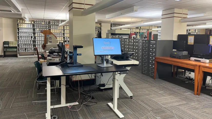 microform shelving with boxes and a table with a computer screen