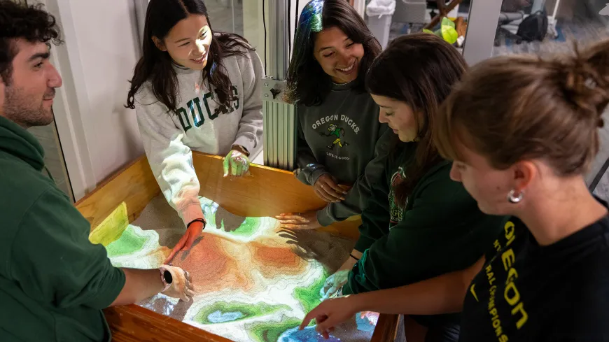 A group of students looking at a topographic table in the DREAM Lab