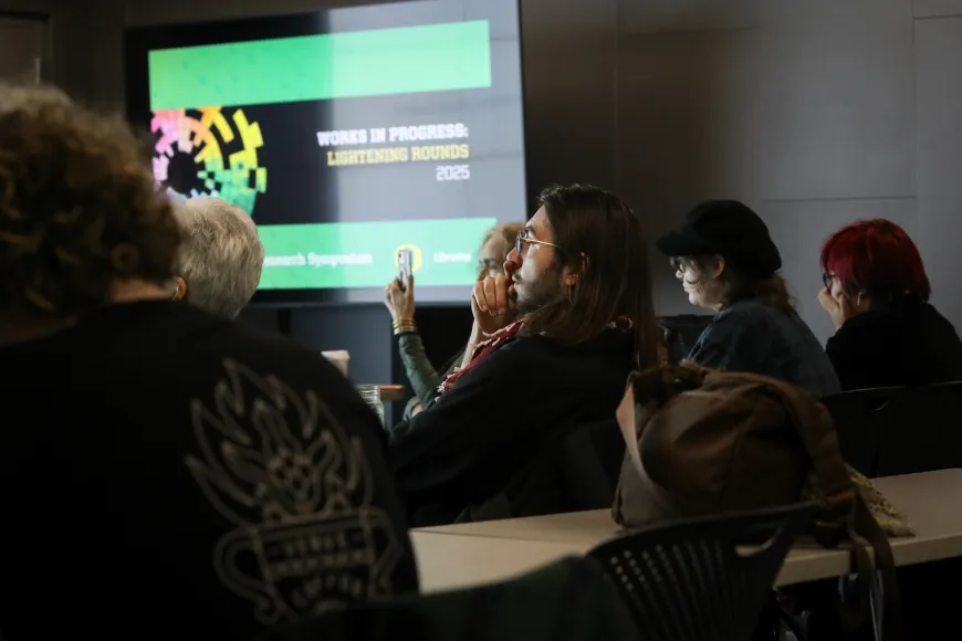 Students and attendees listening to a Works In Progress presentation in the VizLab.