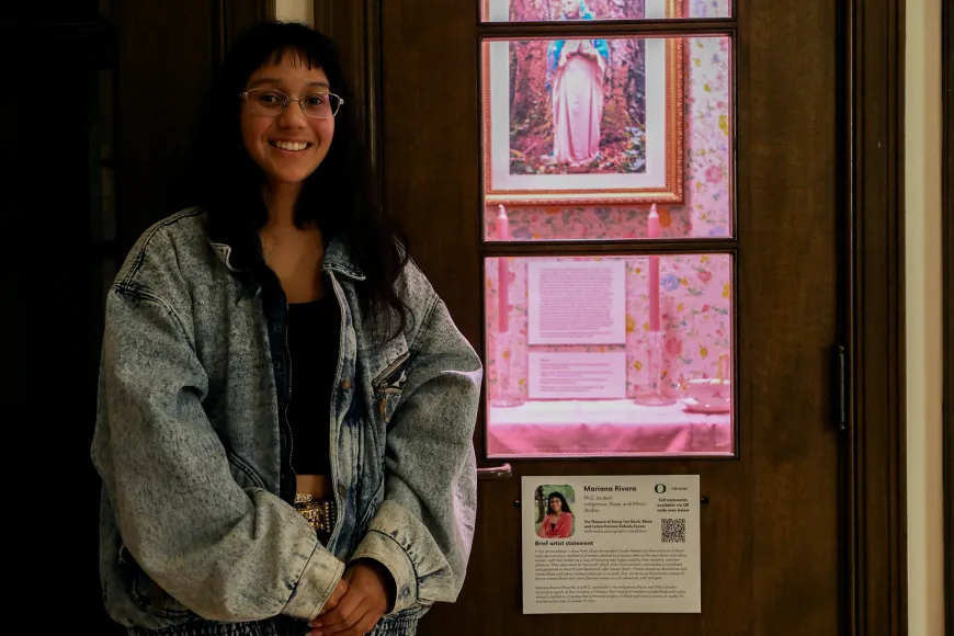 Marianna Rivera standing next to the phone booth housing their exhibit installation.