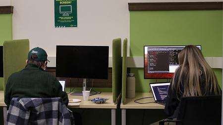 Two students sitting at computers in the GradSpace 