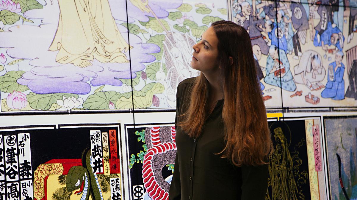 A woman looking at artwork on a large digital screen