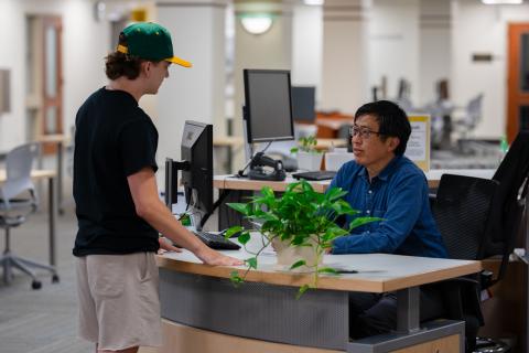 A student at the Knight Library help desk