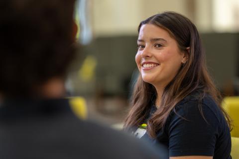 A student looking toward another student and smiling