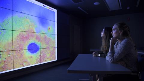 two women looking at the screen in the visualization lab