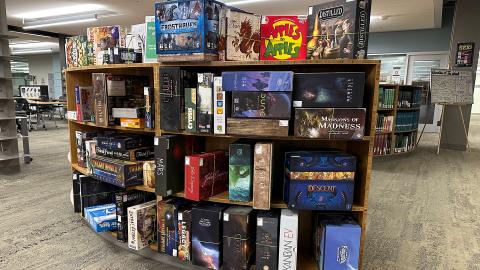 boxes of board games on library shelving