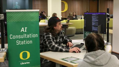 Two people looking at a computer at the AI consultation station