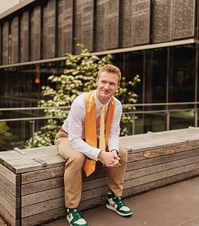 Ethan Lake sitting on a bench outside the Price Science Commons.
