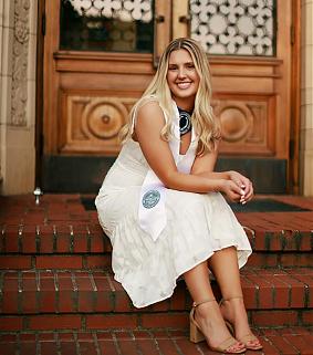 Maddy Duquette sitting on red brick steps.