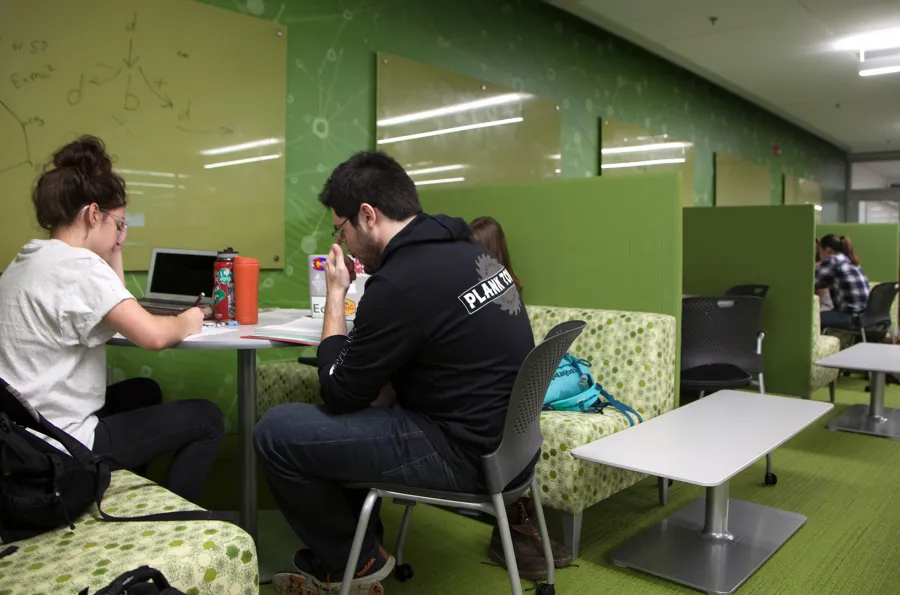 students studying at a booth in a green room