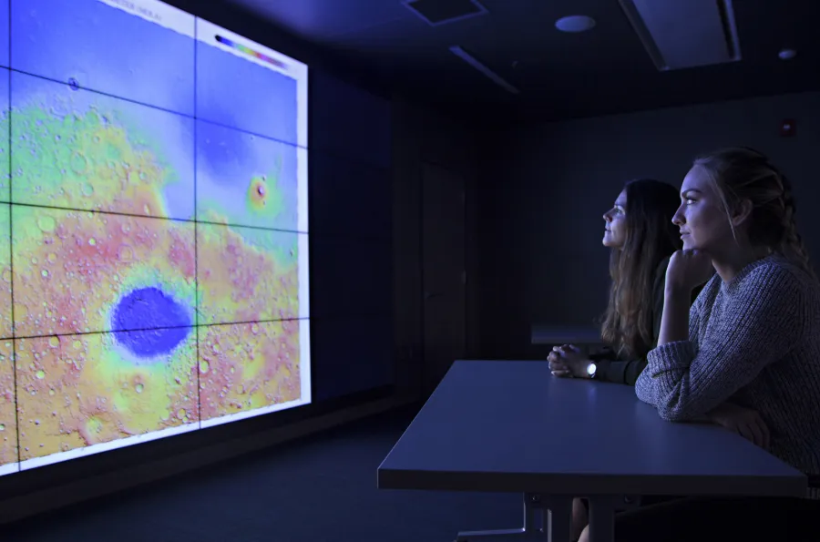 two women looking at the screen in the visualization lab