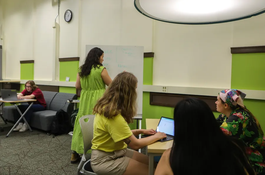 students studying in a group and another student at a laptop