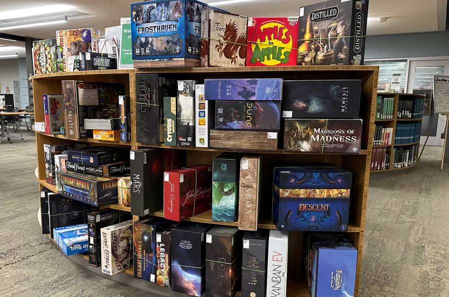 boxes of board games on library shelving