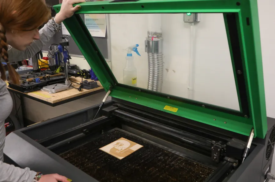 Close up of someone looking into a laser cutter