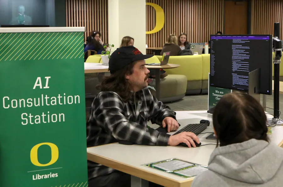 Two people looking at a computer at the AI consultation station