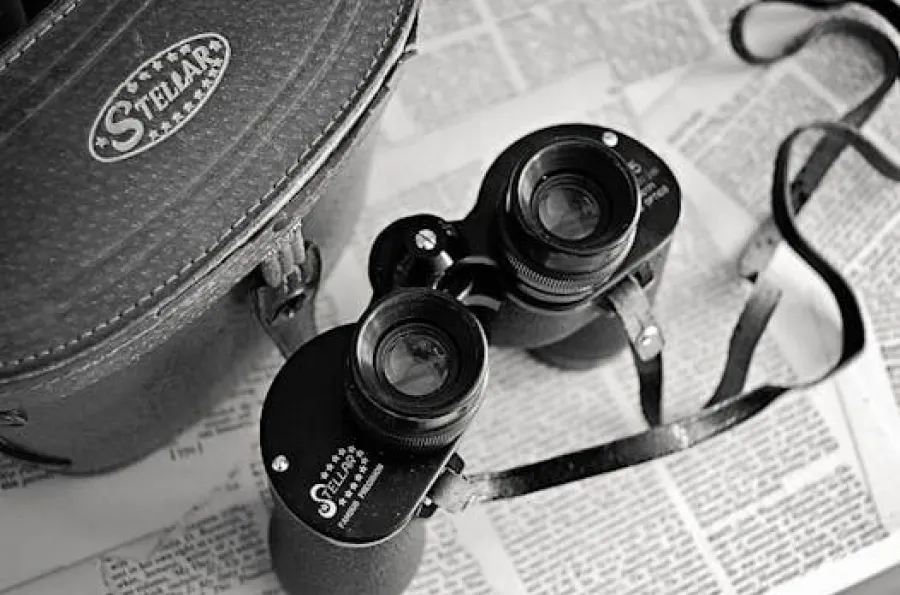 Black and white binoculars placed on top of printed pages from a book.