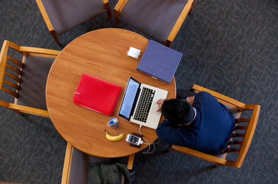 Bird's eye view of student working on a laptop.